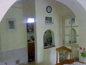 une salle à manger avec une horloge sur un mur dans l'établissement Árnyas Vendégház, à Hajdúszoboszló