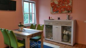 a dining room with a wooden table and green chairs at ferienhaus-raju-zeltingen in Zeltingen-Rachtig
