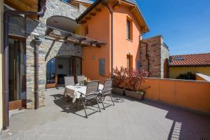 a patio with a table and chairs and a building at Borgo La Sorgente - Erica in Gravedona