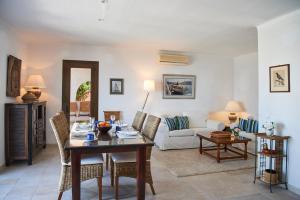 ein Wohnzimmer mit einem Tisch und einem Sofa in der Unterkunft Las Escaleras - Villa DEKA - 2S in Port d’Andratx