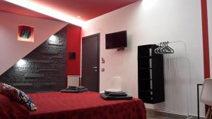 a bedroom with a bed with a red blanket and a tv at EtnaSpecial in Nicolosi