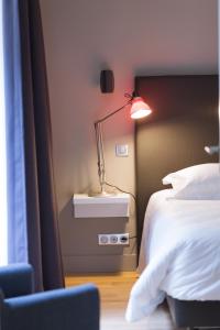 a bedroom with a bed and a lamp on a night stand at T2 bis luxe hyper centre piscine in Bordeaux