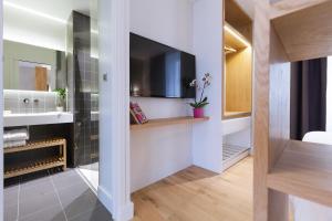 a bathroom with a television and a sink in a room at T2 bis luxe hyper centre piscine in Bordeaux