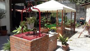 a garden with potted plants and a white umbrella at EtnaSpecial in Nicolosi