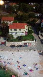 a sandy beach with umbrellas in front of a building at apartmani Isabella - Ilda Radonic in Jelsa