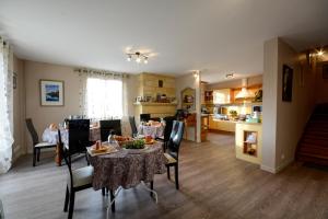 a dining room and kitchen with a table and chairs at La Roseraie in Vitrac