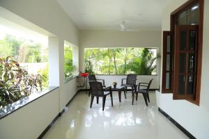 una veranda con sedie, tavolo e finestra di Superior rest a Jaffna