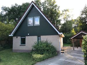 uma casa com um telhado preto e janelas em Villa Anna with sauna in Winterswijk em Winterswijk