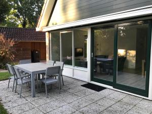 a glass extension of a house with a table and chairs at Villa Anna with sauna in Winterswijk in Winterswijk