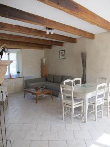 a living room with a table and chairs and a couch at Dans l'Air du Temps in Flagey