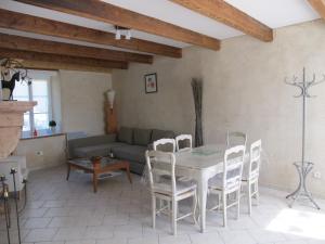 a living room with a table and chairs and a couch at Dans l'Air du Temps in Flagey