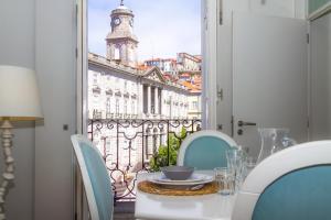 een tafel en stoelen met uitzicht op een gebouw bij Liiiving in Porto | Ribeira Boutique Apartment in Porto