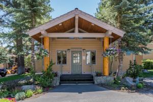 una piccola casa gialla con una porta blu di Mammoth Creek Condos a Mammoth Lakes