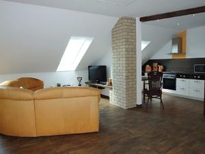 a living room with a couch and a table and a kitchen at Ferienwohnung Kranichzug in Kargow
