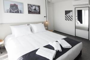 a bedroom with a large white bed with towels on it at White Luxury in Thessaloniki