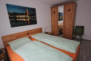 a bedroom with a bed with an orange and white sheets at Ferienwohnung Leer in Leer
