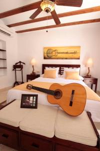 a guitar sitting on a bed in a bedroom at Entre Dos Aguas Hotel Boutique in Toledo