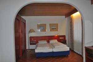 a bedroom with a bed with a red head board at Hotel Starkenburger Hof in Heppenheim an der Bergstrasse