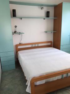 1 dormitorio con 1 cama con sábanas blancas y armarios azules en Villino vicino al mare, en Budoni