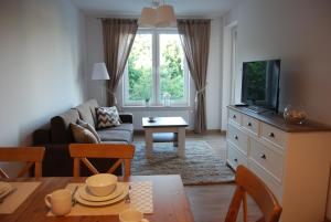 Televízia a/alebo spoločenská miestnosť v ubytovaní Apartament Piaskowy Polanki Park