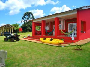 a red house with a yellow boat on the front of it at Hospedagem - Eco Pousada Sinhá Ruth - Patrimônio - 22km de Brotas in Brotas