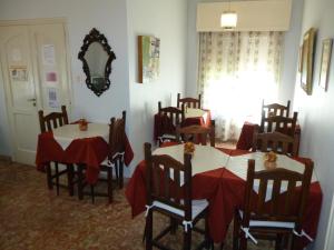 een eetkamer met twee tafels en stoelen en een spiegel bij Belvedere Hotel para Adultos in Santa Rosa de Calamuchita