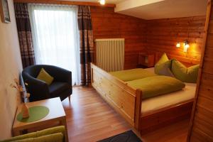 een slaapkamer met een bed en een stoel in een kamer bij Ferienhaus Melmer Florian in Sankt Leonhard im Pitztal