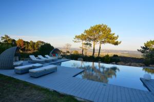 une piscine avec des canapés et des chaises sur un patio dans l'établissement The Fig Boutique Suites, à Salir de Porto