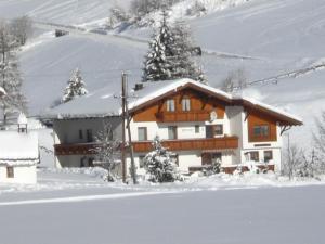 een huis in de sneeuw met sneeuw bedekte bomen bij Ferienhaus Melmer Florian in Sankt Leonhard im Pitztal