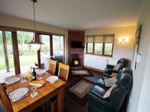 a living room with a dining room table and a fireplace at LLanddewi Retreat in Llanddewi Ystradenny