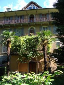a large building with palm trees in front of it at B&B I Lamponi in Varzo