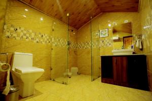 a bathroom with a toilet and a glass shower at Amara Resorts Manali in Manāli +63 photos