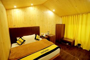 a bedroom with a bed in a room with wooden walls at Amara Resorts Manali in Manāli