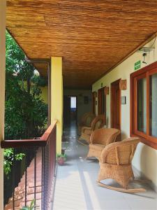 une terrasse couverte avec des chaises en osier et un plafond en bois dans l'établissement Hotel Casa Vínculos, à Estelí