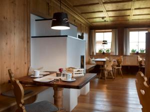 uma sala de jantar com uma mesa de madeira com cadeiras e uma sala de jantar em Bauernhof Zwiglhof em San Candido