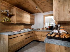 une grande cuisine avec des placards en bois et un comptoir. dans l'établissement Bauernhof Zwiglhof, à San Candido