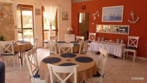 a restaurant with tables and chairs in a room at Toscana Lakeside Apartments I - II Family friend in Siófok