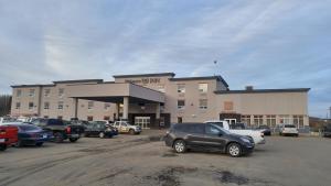 a parking lot with cars parked in front of a building at Wabasca Inn in Wabasca