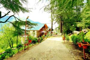 a dirt road in front of a house with potted plants at Amara Resorts Manali in Manāli