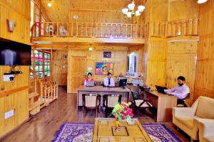 three people sitting at a table in a room at Amara Resorts Manali in Manāli