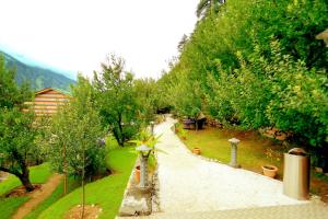 a path in a garden with trees and bushes at Amara Resorts Manali in Manāli