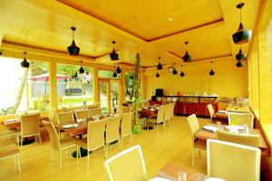 a restaurant with tables and chairs in a room at Amara Resorts Manali in Manāli