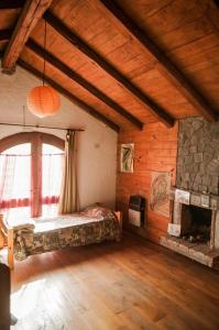 Habitación grande con cama y chimenea. en Wayra Waka, en Villa Giardino