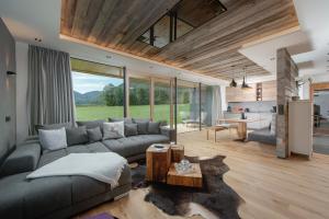 ein Wohnzimmer mit einem Sofa und einem Tisch in der Unterkunft Stoaberg Lodge in Sankt Ulrich am Pillersee
