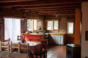 una cocina con mesa y sillas y una cocina con ventanas en Wayra Waka, en Villa Giardino 27 fotos más