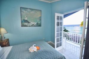 Schlafzimmer mit einem Bett und Meerblick in der Unterkunft Moon San Villa at the Blue Lagoon in Port Antonio