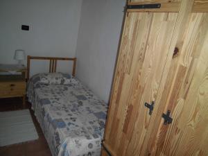 - une chambre avec un lit et une porte en bois dans l'établissement La Casa Antica, à Pont-Saint-Martin