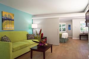 sala de estar con sofá verde y dormitorio en Silver Palms Inn, en Key West