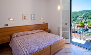 Un dormitorio con una cama y un balcón. en Albergo Franzone, en Tovo San Giacomo
