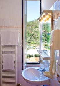Un baño con lavabo y ventana. en Albergo Franzone, en Tovo San Giacomo